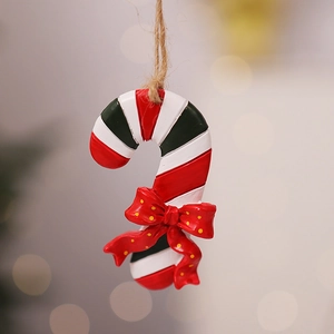 Close-up of a resin candy cane ornament with a red polka dot bow for Christmas trees