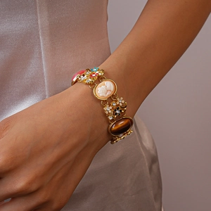 Detail eines Vintage-Kamee-Armbands mit Tigerauge-Stein und Harzblumen auf Goldkette