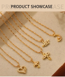 Detail of five gold-plated necklaces with crystal pendants on beige linen background