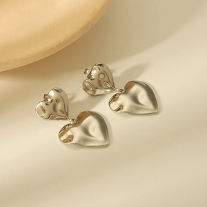Detail of silver double heart earrings showing the polished finish and metallic texture