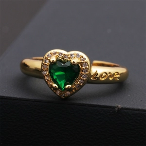 Vue macro d'une bague coeur en zircon vert avec gravure Love et placage en or 18 carats