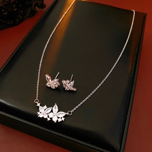 Détail d'un ensemble collier et boucles d'oreilles papillon en argent avec zircons