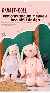 Detail of soft pink rabbit plush dolls wearing floral dresses in a cozy indoor setting