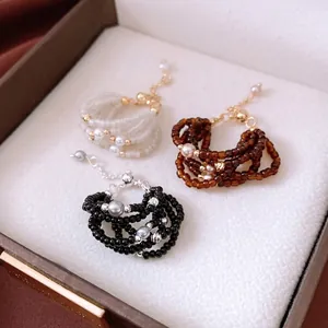 Three-layer glass bead adjustable rings in cream, amber, and black with pearl accents