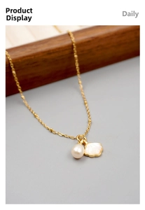Detail of gold necklace featuring freshwater pearl and white shell petal pendant