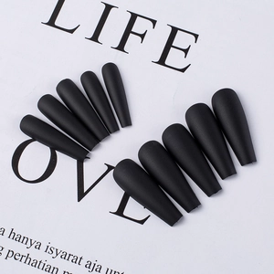 Flat lay of matte black coffin press-on nails displayed on a white background prop