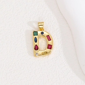 Detailed view of golden letter D pendant with colorful square and round zircon stones
