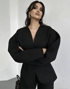 Détail de la robe blazer noire pour femme avec col en V et manches bouffantes à silhouette