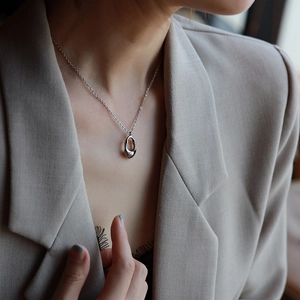Elegant minimalist silver hollow teardrop pendant necklace for women on a model