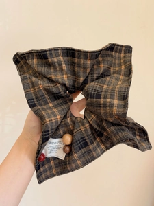 Detail of plaid scrunchie with brown checkered fabric and decorative beads