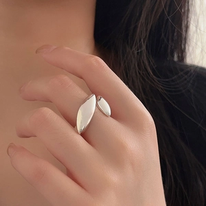 Close-up of a minimalist silver olive leaf open ring worn on a finger