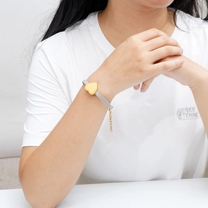 Dettaglio ciondolo a cuore oro 18K su cinturino in maglia di acciaio inossidabile