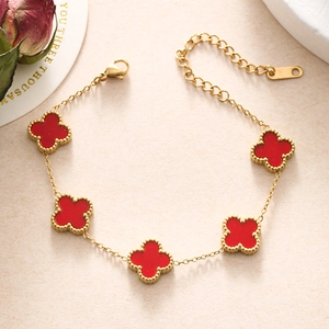 Close-up of golden beaded edging and red clover clover-shaped motifs on a delicate chain