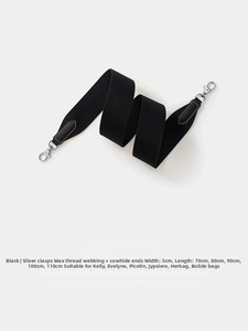 Detail of 5cm wide black woven strap with leather ends and silver-toned metal hardware