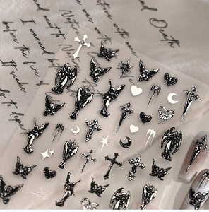 Macro shot of Gothic nail stickers featuring black angels, crosses, and thorns on vintage paper