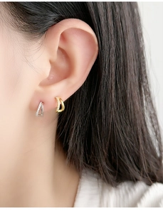 Close-up of double-layer crisscross gold and silver hoop earrings with sparkling crystals