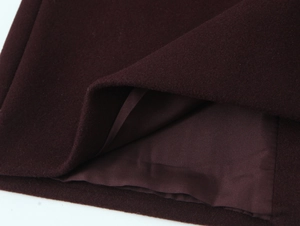Detailed close-up of wine red wool coat hem with smooth matching inner lining