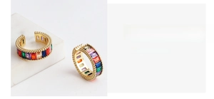Macro shot of adjustable gold rings with vibrant rainbow-colored zircon stone settings