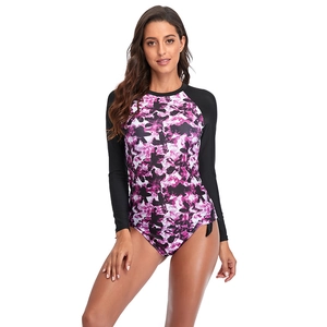 Détail d'un maillot de bain à manches longues avec imprimé floral violet et noir pour le surf