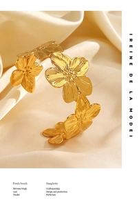 Dettaglio macro del bracciale fiore di ciliegio dorato con texture spazzolata e petali 3D