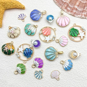 Flat lay of colorful enamel shell and starfish pendants with pearls for jewelry making