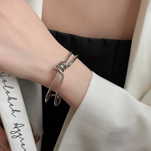 Detail of silver metallic knot bracelet showing the polished double twisted design on wrist