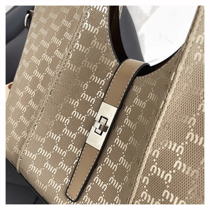 Detailed view of jacquard fabric texture with metal twist lock on the beige tote bag