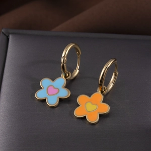 Boucles d'oreilles créoles fleurs colorées en acier inoxydable sur socle sombre