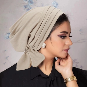 Elegant beige pleated turban hat for women with a side bow accent and soft textured finish