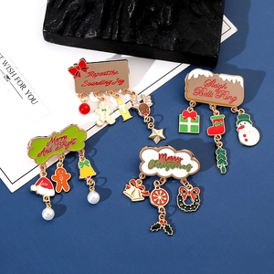Close-up of four festive Christmas enamel brooches with Santa hat and reindeer charms