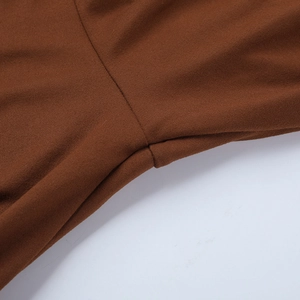 Macro shot of precise stitching and texture on brown knitted backless jumpsuit fabric