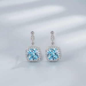 Detailed macro view of S925 silver halo earrings with square blue gemstone drops