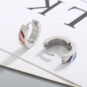 Detailed close-up of silver steel earrings with multi-color rainbow enamel stripes