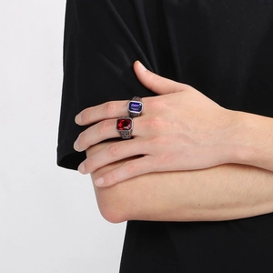 Detail of luxury men's viking style ring with large red and blue square gemstones
