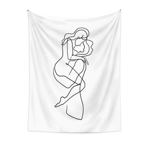 Detail of minimalist line art tapestry showing black abstract figures on white fabric
