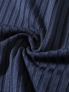 Detailed close-up of dark pleated fabric with high-density vertical ribbed texture