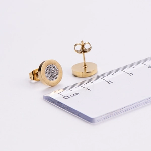 Close-up of gold-plated stainless steel stud earring with rhinestones and scale ruler