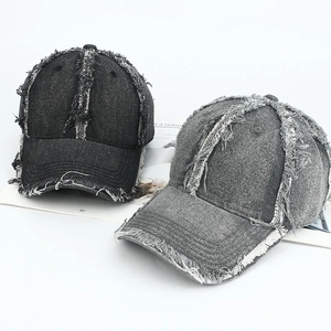 Detail of distressed denim baseball caps with frayed edges and vintage washed finish