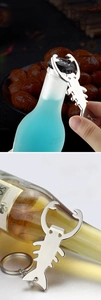 Zinc alloy scorpion-shaped bottle opener showing practical use on a soda bottle