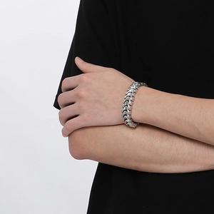 Macro detail of men's vintage dragon bone silver chain bracelet on model wrist