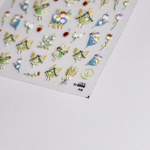 Detailed macro view of 3D embossed nail stickers featuring fairy and tulip floral designs