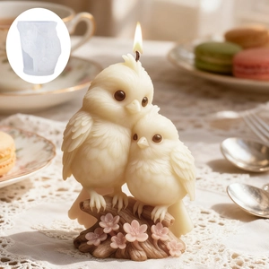 Detail view of bird and cherry blossom silicone mold with a lit candle finished product