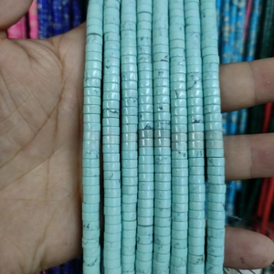 Close-up of sky blue disc-shaped synthetic turquoise beads with black stone texture for DIY jewelry