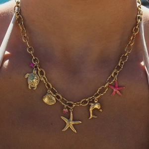 Detail of gold ocean themed necklace with sea turtle, starfish and colorful gemstones