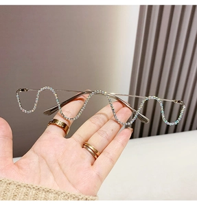 Close-up of wavy metal chain frame with aurora rhinestones on rimless glasses