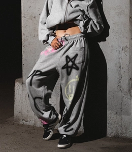 Détail d'un ensemble jogging gris orné de motifs graffitis colorés à la peinture aérosol