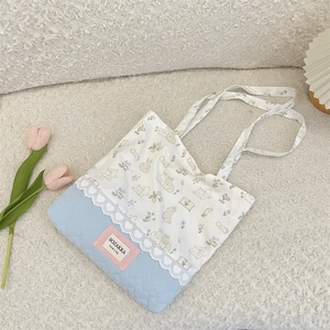 Detail of cute tote bag showing floral bunny print and blue heart quilted fabric