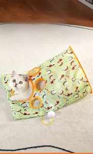 Close-up of cat crinkle bag toy with cartoon patterns and hanging white pom-pom detail