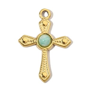 Detail of a gold-plated cross pendant with a centered light green gemstone on white background