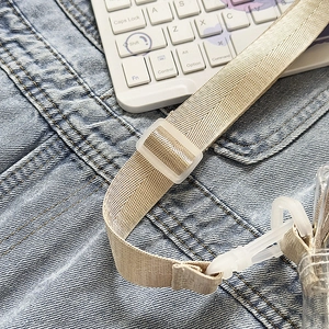 Detail of cream woven shoulder strap with translucent frosted buckle for Kapibara bag